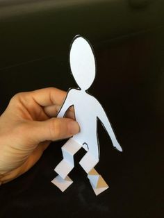 a person holding up a cut out paper figure