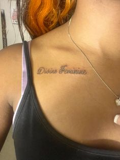 the back of a woman's neck with her name written on it and an orange hair