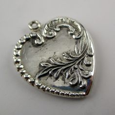 "This antiqued sterling silver, two-sided Acanthus Heart charm features a complex design of Victorian beads, musical clefs, and showy foliage. Made by Brown County Silver. Vintage and in new, never worn condition. Approximately 30 years old. 1 1/8\" high 1\" wide 3.7 grams *Notice this heart does not include a jump ring See more @ https://www.etsy.com/shop/brocosi" Silver Heart Bead Pendant Necklace, Silver Heart Pendant Necklace With Heart Beads, Nickel-free Silver Heart Necklace For Memorials, Nickel-free Silver Heart Necklace For Memorial, Silver Nickel-free Heart Necklace For Memorial, Silver Heart-shaped Etched Jewelry, Etched Heart Silver Jewelry, Etched Heart Shaped Silver Jewelry, Silver Double Heart Necklace With Heart Beads