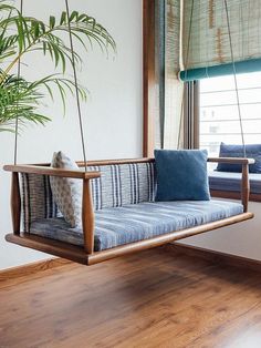 a blue and white striped couch hanging from a wooden frame in front of a window