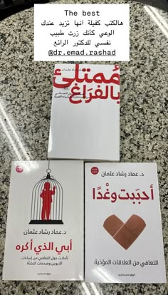 three books in arabic and english on a counter top with an advertisement for the book