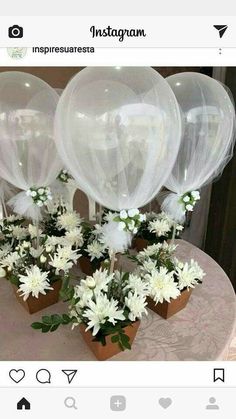 some white flowers and balloons on a table