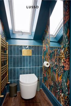 a bathroom with blue walls and wooden flooring has a skylight above the bathtub