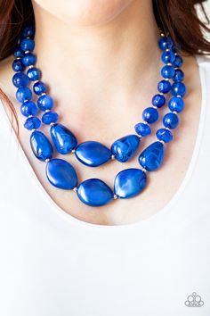 a woman is wearing a blue necklace with large beads