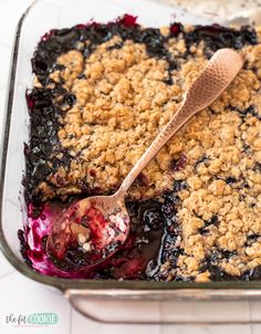 blueberry crumbled dessert in a baking dish with a spoon