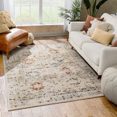 a living room with a couch, chair and rug on the floor in front of a window