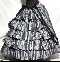 #C8/5, H5/4 this 2 pcs steampunk gothic outfit Ballroom steel Grey Taffeta Skirt and Tulle net bone patticote hoop including in this sale .  skirt has 3 layers and with black 3D roses Braiding all the way round the apron (top layer), 2nd layers is tiered and it's fully lined. Waist is elasticated with toggle for waist adjustment. Skirt is one size  Boned under skirt with 2 black Tula layers (please refer to photos) and has valcro fasteners.  Skirt front and back length. - 41" approximately  Plea Gothic Skirt For Halloween Costume, Gothic Black Skirt For Larp, Gothic Halloween Costume Skirt, Gothic Mini Skirt For Cosplay, Steampunk Corset Dress With Ruffles For Cosplay, Steampunk Ruffled Corset Dress For Cosplay, Gothic Skirt For Costume Party, Steampunk Corset Dress With Ruffles For Halloween, Gothic Corset Dress With Attached Cancan For Cosplay