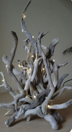 a sculpture made out of driftwood with lights on the sides and branches in the middle