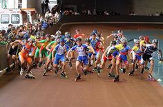 a large group of rollerblades are racing down the street in front of spectators