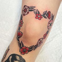 a close up of a person's leg with flowers and a bird on it