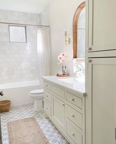 a bathroom with white cabinets and tile flooring