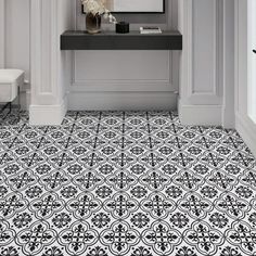 a black and white tile floor in a bathroom with a mirror on the wall above it