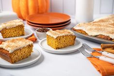 pumpkin desserts with frosting on white plates and orange napkins next to each other