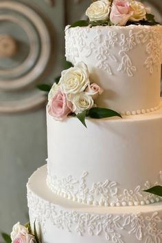 a wedding cake with white frosting and pink flowers