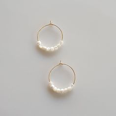 Introducing our exquisite Dainty Pearl Hoop Earrings, a harmonious blend of elegance and charm. Crafted with a touch of glamour, these Gold Hoop earrings effortlessly exude a minimalist appeal. Handmade using premium materials, including lustrous Mother of Pearl, these earrings are the epitome of refined beauty. Delicate and glimmering, they are the perfect accessory to elevate any look. Whether you're searching for a gift for Mom or a special Birthday gift for her, these Handmade Pearl Jewelry Handmade Pearl Jewelry, Gift For Mom Birthday, Minimalist Earrings Gold, Earrings Gold Hoop, Earring Handmade, Hoop Earrings Gold, Pearl Hoop Earrings, Pearl Jewellery Earrings, Gold Earring