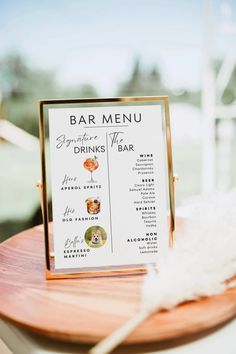 a menu sitting on top of a wooden table next to a white and orange feather