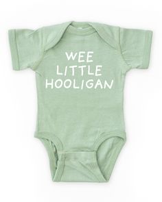 A funny and cute baby boy outfit for St. Patrick's Day! Features a white "wee little hooligan" print on our cozy gender neutral baby bodysuit. Made from buttery-soft airlume cotton that provides all day comfort, breathability and flexibility for all activity levels. ☑ 100% combed ringspun cotton☑ Buttery-soft, light-weight & breathable material☑ Gender neutral bodysuit☑ Flatlock seams☑ Double-needle ribbed binding on neck, shoulders, sleeves & leg opening☑ Reinforced three-snap closure☑ EasyTear Funny Gender Neutral Gifts, Gender Nuteral Baby Outfits, Neutral Baby Boy Clothes, Gender Neutral Baby Outfits, Cute Onesies For Babies, Neutral Bodysuit, Baby Clothes Gender Neutral, Gender Neutral Outfits, Fitted Bodysuit