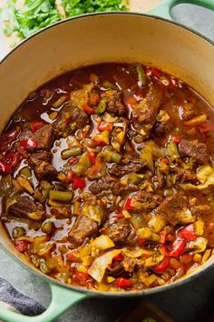 a pot filled with stew and vegetables on top of a table