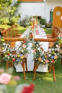 the table is set up with flowers and letters on it for an outdoor wedding reception