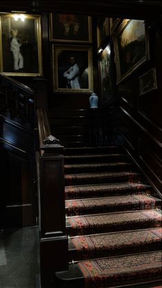 the stairs are lined with paintings and rugs