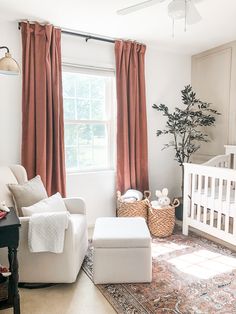 a baby's room with a crib, chair, and ottoman in it