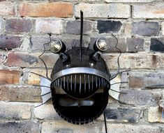 a grill mounted to the side of a brick wall with two lights on it's sides