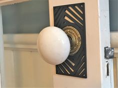 a white door knob with a black and gold design on it