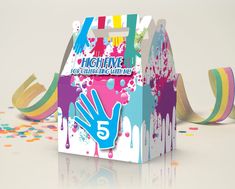 an open box with colorful paint splattered on it and streamers around it