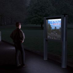 a person standing in front of a television at night with the screen showing an event