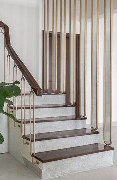 a set of stairs with metal railings and wood handrails in a white room