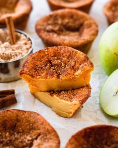 apple pies with cinnamon sugar in the middle and apples on the side next to them