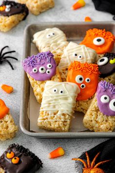 halloween rice krispy treats on a tray with candy eyes and spider webs in the background