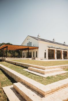 a large white building sitting on top of a lush green field