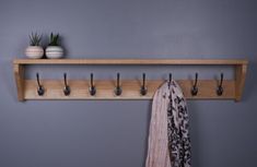 a coat rack with several hooks on it next to a towel and potted plant