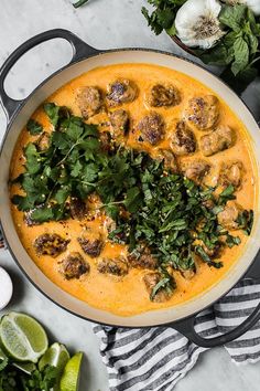 a pan filled with meatballs and cilantro sauce