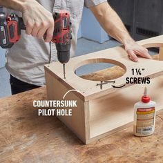 a man working on a piece of wood with two drillers and screwdrivers