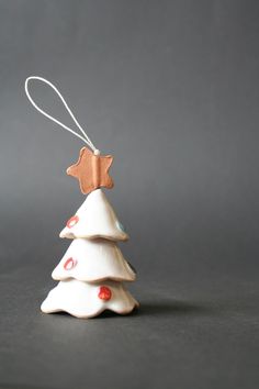 a white ceramic christmas tree ornament with a brown star on it's top