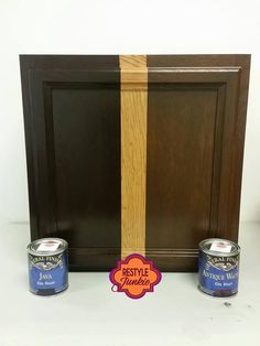 two cans of paint sitting on top of a counter next to a wooden frame and door