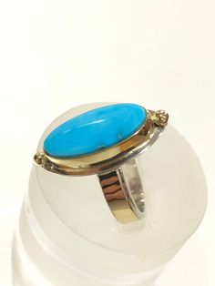 "This modern Natural Sleeping Beauty Turquoise ring was fabricated in my studio using 18k Gold, and Sterling Silver. This gorgeous all natural Sleeping Beauty Turquoise Blue cabochon is worthy to be set in gold. The cabochon is set with a 1/8\" tall 18k bezel. The sterling silver rectangle ring band is adorned with a 1/8\" wide 30 gauge strip of 18k Gold. The bezel, 18k Gold Beads, and band are soldered on a 24 gauge Sterling Silver back plate. The Ring is nearly 1\" ( 23.2 mm ) long x 7/16\" (1 Rectangle Ring, Silversmith Jewellery, Arizona Turquoise, Sterling Silver Rings Bands, Royston Turquoise, Sleeping Beauty Turquoise, Blue Gems, Silver Band Ring, Hand Made Jewelry