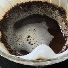 a glass bowl filled with brown liquid on top of a stove