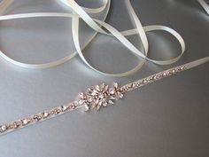 "This sparkly skinny bridal belt is made with Swarovski crystals beaded on 3/8\" wide satin ribbon. The crystal part of the bealt measures 12 1/2\" long and 1 1/8\" wide in the center. The entire sash measures 150\" long. Available in gold, silver or rose gold finish and with satin or grosgrain ribbon. For the photo of the satin ribbon color options, please take a look here: https://www.etsy.com/listing/248390980/rose-gold-bridal-crystal-belt-crystal?ref=shop_home_active_22 For the photo of the Elegant Adjustable Embellished Bridal Belt, Elegant Embellished Adjustable Bridal Belt, Adjustable Bridal Belt With Sashes For Party, Adjustable Bridesmaid Bridal Belt With Sashes, Adjustable Bridal Belt With Sashes For Bridesmaid, Adjustable Sashes Bridal Belt For Party, Elegant Gold Bridal Belt For Bridesmaids, Adjustable Embellished Bridal Belt For Wedding, Bridal Hair Veil