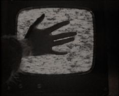 a hand on top of a television screen