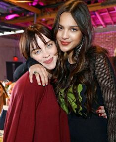 two young women hugging each other in a room