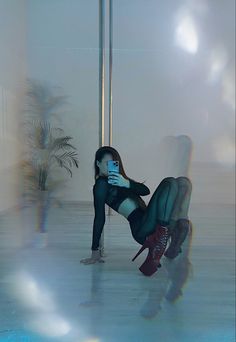 a woman leaning on a pole while holding a cell phone