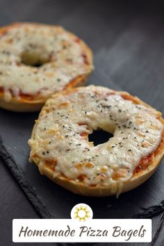 two homemade pizza bagels sitting on top of a table