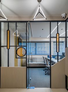 an office cubicle with glass partitions and modern lighting