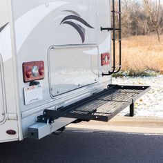 an rv parked on the side of the road with its door open and snow covered ground