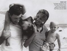 an old black and white photo of two adults and three children on the beach with one child holding his dad's head