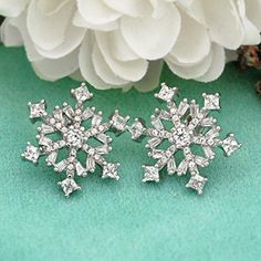 Discover elegance and sophistication with our Sterling Silver Cubic Zirconia Winter Snowflake Flower Stud Earrings, meticulously crafted by Innovato Design. Embrace the beauty of winter with these exquisite earrings featuring intricately designed snowflake flowers adorned with shimmering cubic zirconia. Made from high-quality sterling silver, these earrings exude timeless charm and grace. Perfect for adding a touch of sparkle to any ensemble, these stud earrings are versatile and elegant, making them suitable for both formal occasions and everyday wear. Their clear cubic zirconia stones catch the light beautifully, ensuring you shine wherever you go. Elevate your style and embrace the magic of winter with our Sterling Silver Cubic Zirconia Winter Snowflake Flower Stud Earrings, crafted wit White Snowflake Wedding Earrings, Elegant Snowflake Earrings For Winter, Elegant Winter Earrings For Pierced Ears, Elegant Jewelry For Anniversary In Winter, Elegant Winter Earrings, Silver Snowflake Cubic Zirconia Earrings, Elegant Snowflake Earrings For Parties, Elegant Winter Earrings For Party, Elegant Winter Jewelry