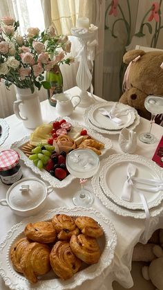 the table is set with croissants and fruit